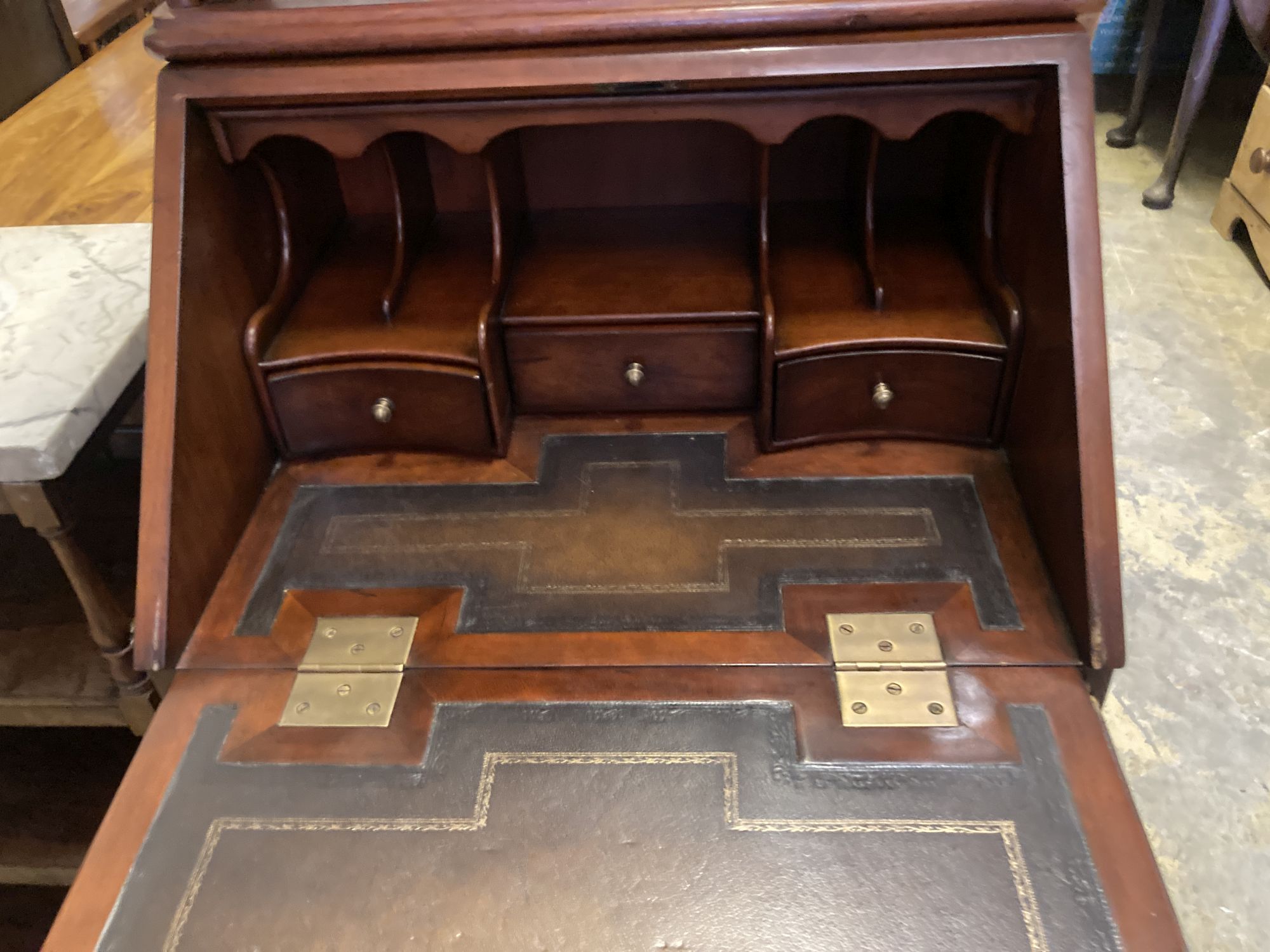 A small reproduction mahogany bureau, width 55cm, depth 43cm, height 102cm together with a three tier wall bracket